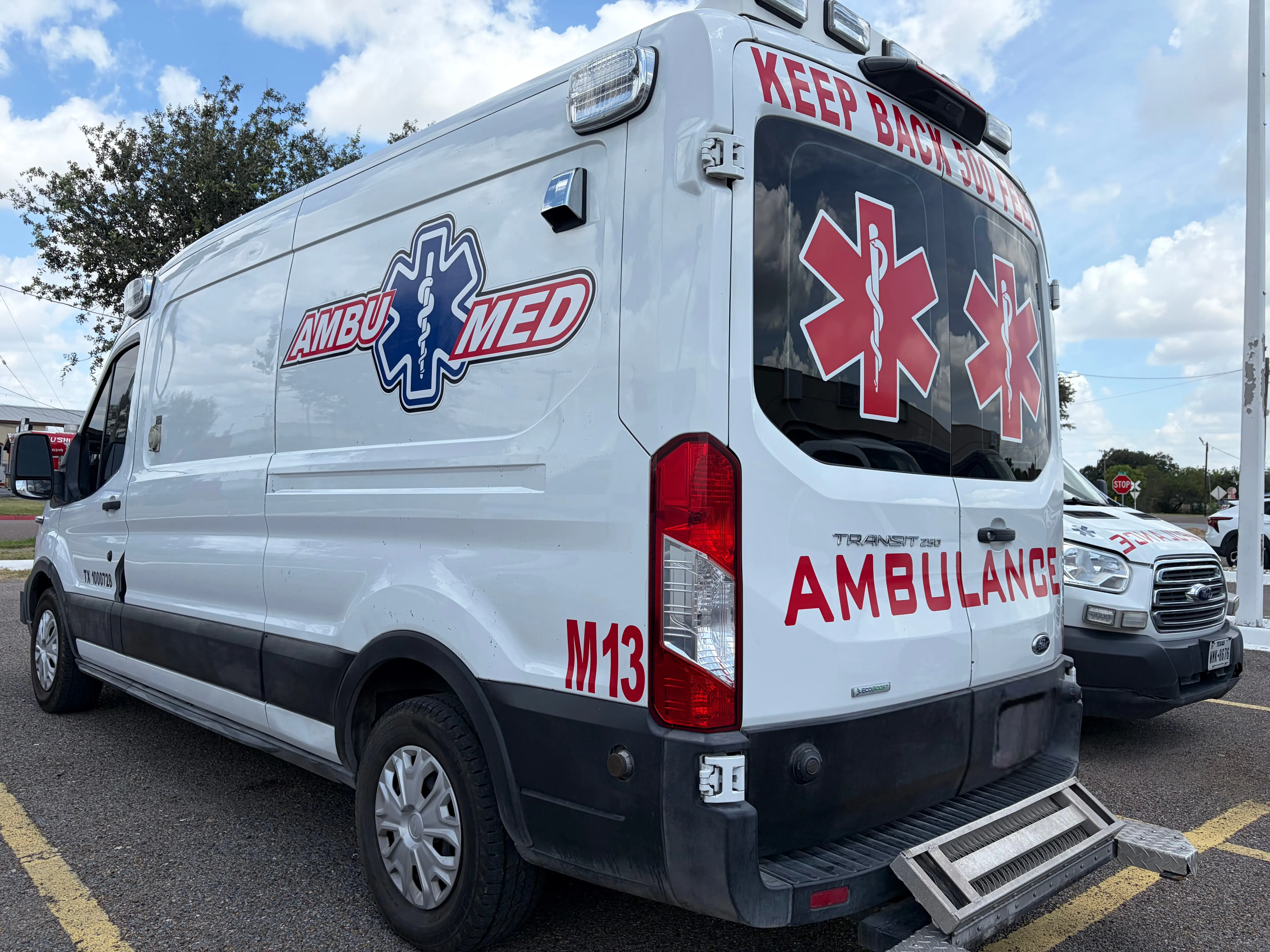 White wheelchair-accessible medical transport van parked in front of a medical facility